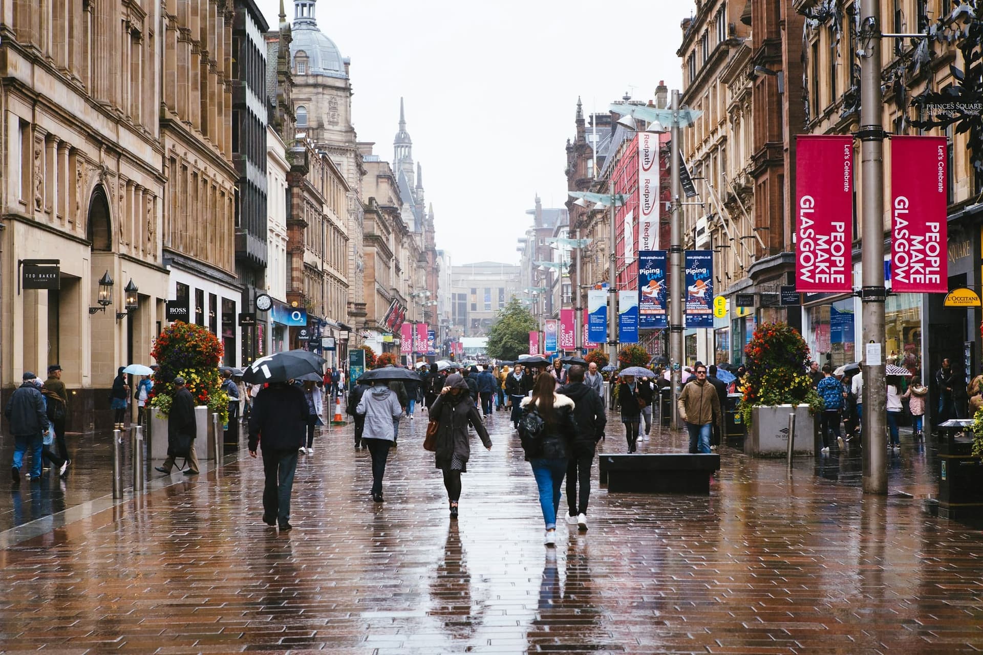 Shoppers with umbrellas on a busy Glasgow street in the rain